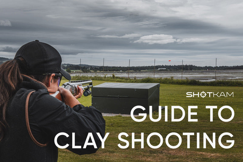 Shooter aiming at an orange clay pigeon during an outdoor ShotKam session