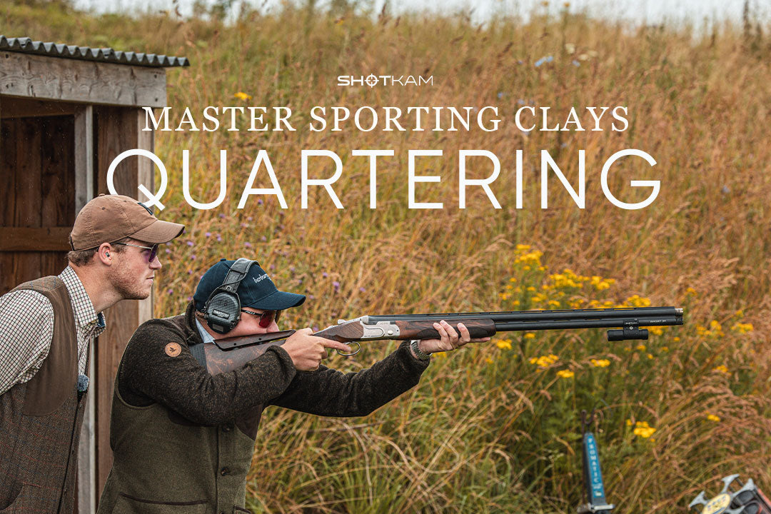 Close-up of a sporting clays coach helping a shooter line up a shot on quartering targets with a ShotKam-equipped shotgun.