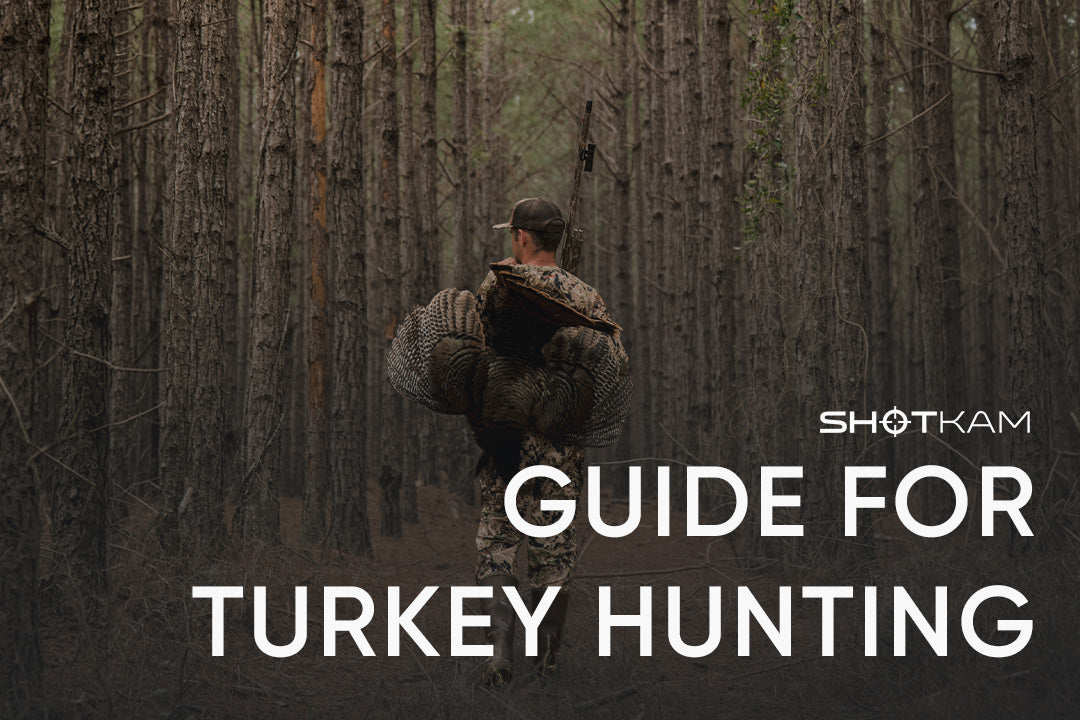 Hunter walking through tall trees with turkey over shoulder and ShotKam recording from barrel