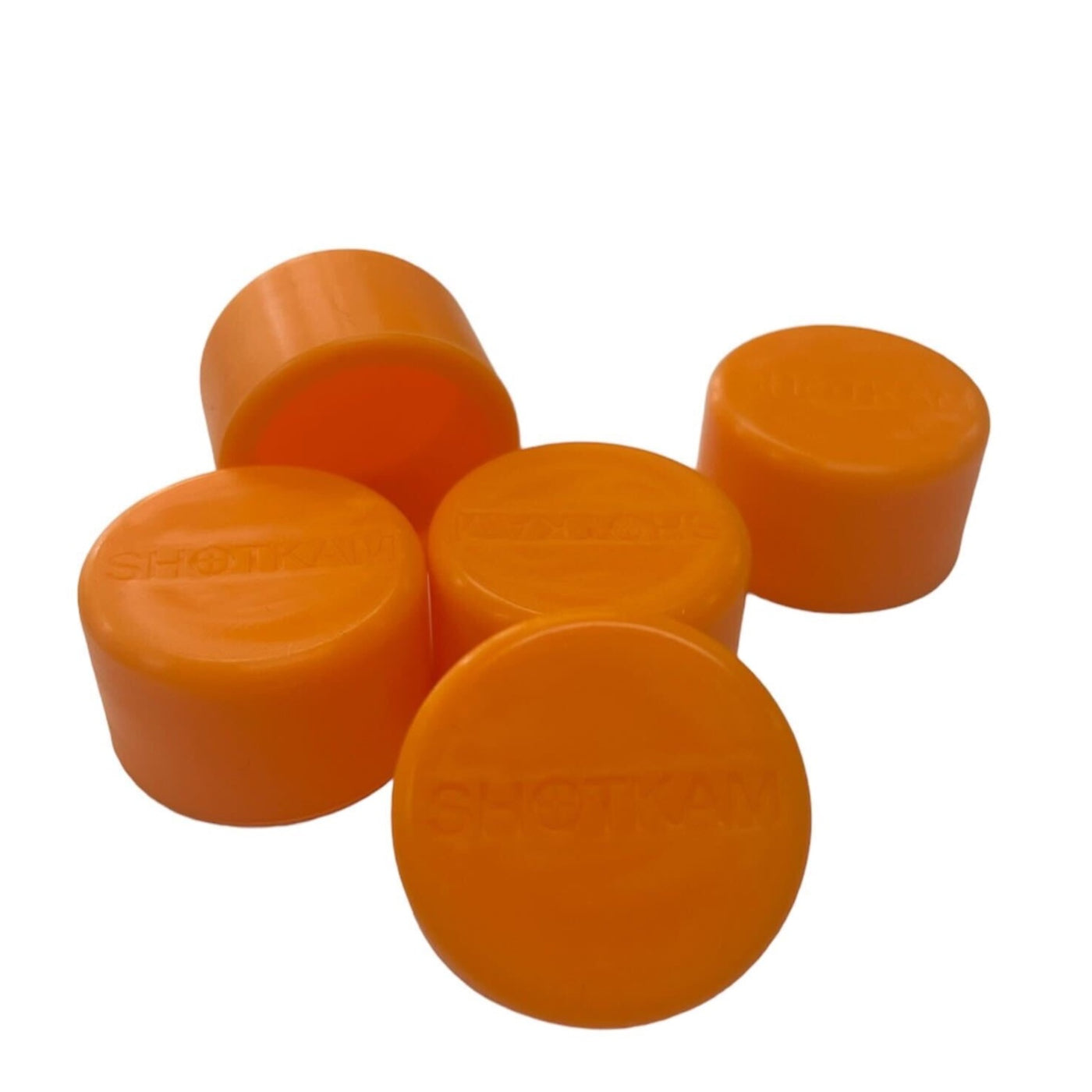 Five orange ShotKam lens covers made of soft plastic, designed to protect the camera lens from damage.